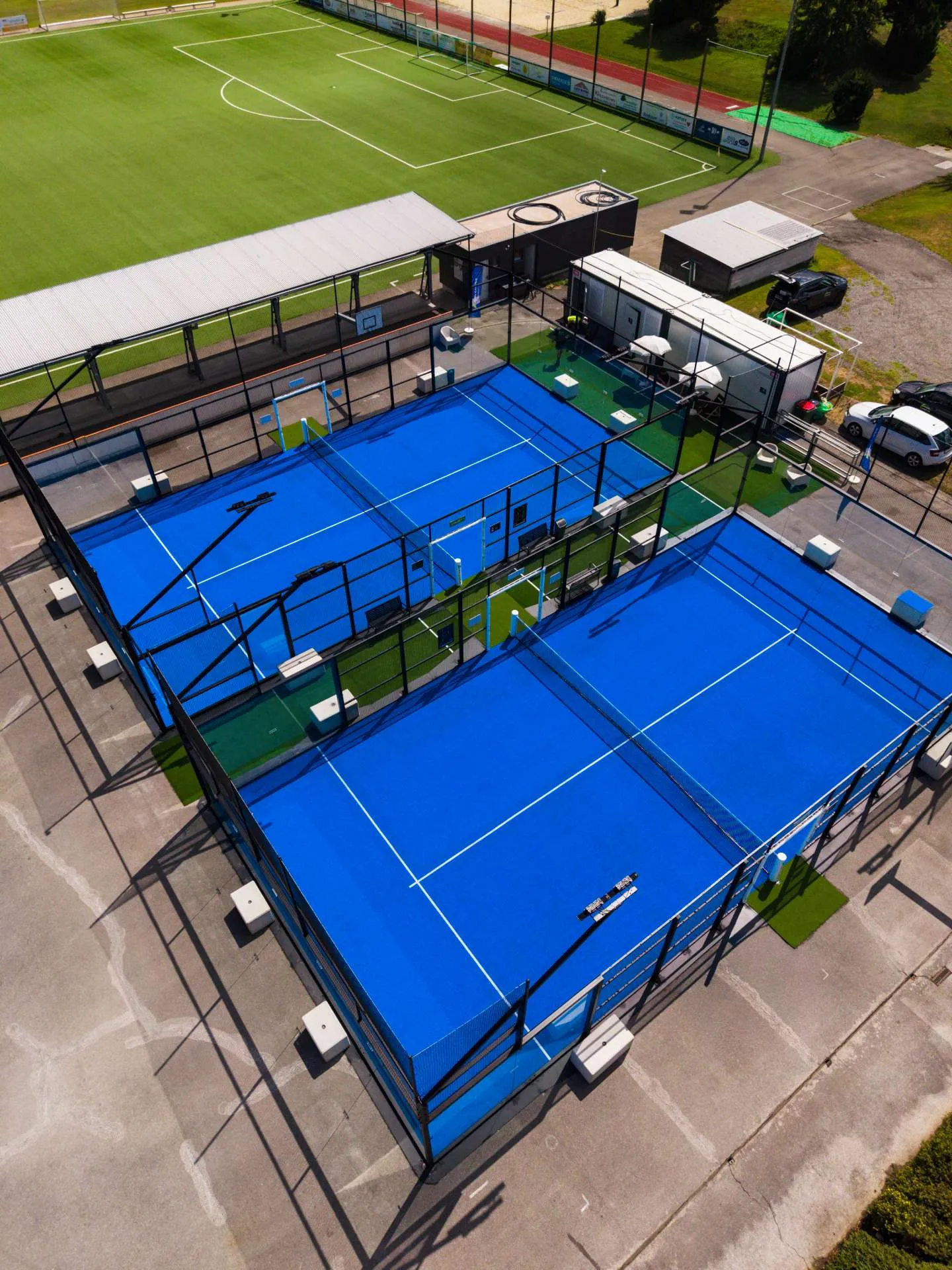 Luftaufnahme von zwei Outdoor-Padel-Courts mit Glaswänden und Gittern