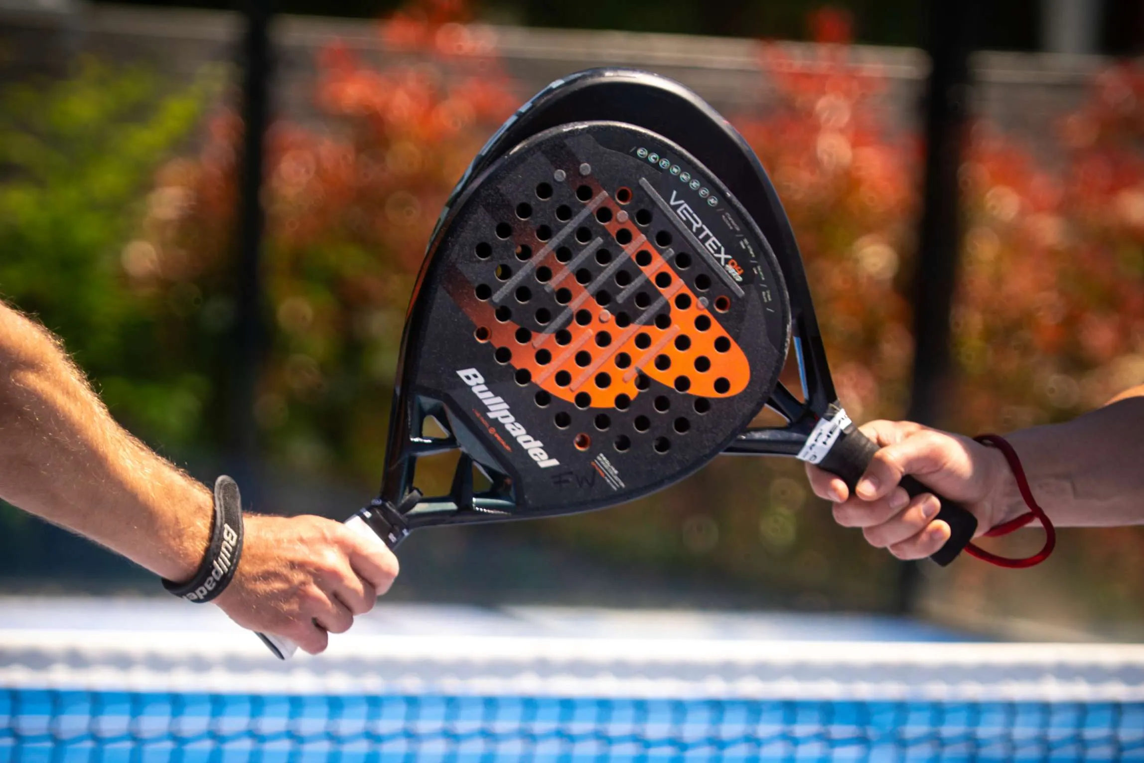 Zwei Padel-Schläger kreuzen sich über dem Netz